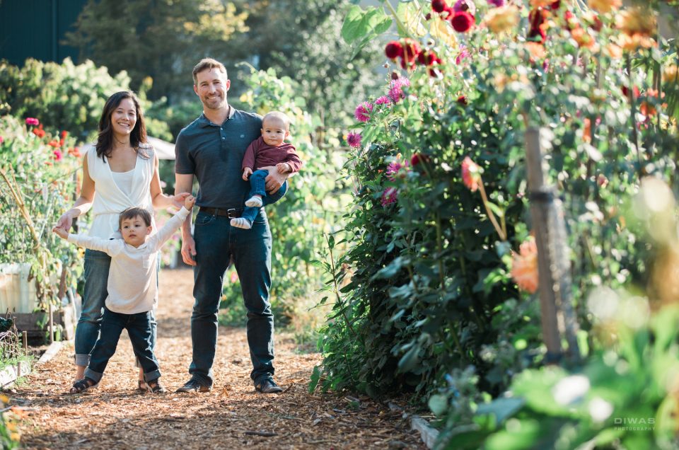 biracial family of four in a community garden
